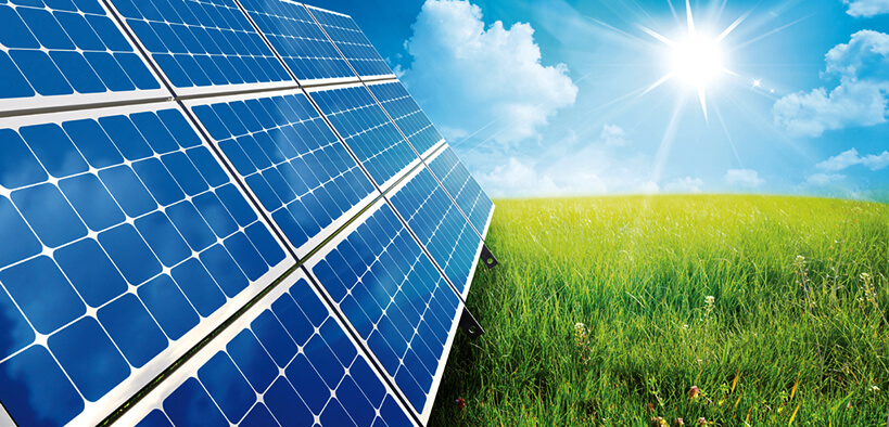 Solar panels in field with sun in sky